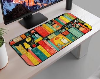 May include: A rectangular desk mat with a vibrant illustration of books, plants, and a cat. The design showcases book spines in red, yellow, and blue, alongside potted plants and a cat at a table under a lamp. The mat is on a white desk.