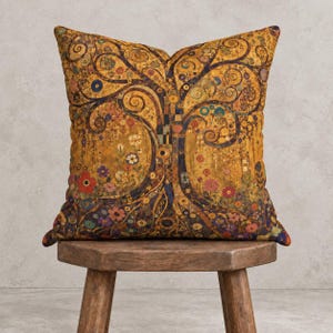 Peut inclure: Un coussin carré arborant un motif d'arbre de vie doré avec des branches tourbillonnantes complexes, des motifs géométriques et de petites fleurs colorées dans des tons de rouge, violet et bleu sur un fond jaune moutarde texturé.