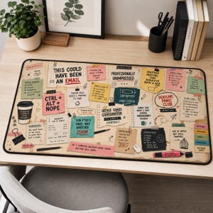 May include: A rectangular desk mat featuring a collage of office-themed sticky notes, checklists, and humorous text such as 'This could have been an email', 'Deadline Panic Club', and 'Office Chaos Coordinator' on a light tan background.