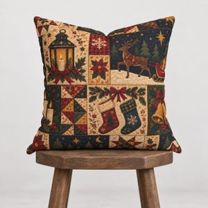 Puede incluir: Un cojín cuadrado con un estampado navideño estilo patchwork. El diseño incluye ilustraciones de una linterna, un reno tirando de un trineo, calcetines, campanas, velas, flores de pascua y abetos en tonos rojos, verdes y dorados.