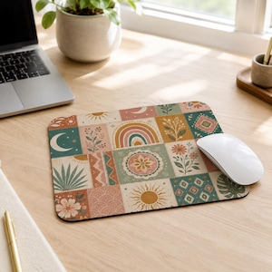 May include: A rectangular mouse pad featuring a patchwork design of various illustrations including a rainbow, suns, moons, flowers, leaves, and geometric patterns in a muted color palette of terracotta, sage green, mustard yellow, and cream.