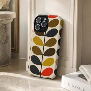 May include: A smartphone case featuring a cream-coloured background with a repeating pattern of stylised leaves in shades of dark grey, brown, mustard yellow, and bright orange, arranged symmetrically along a central vertical black stem line.
