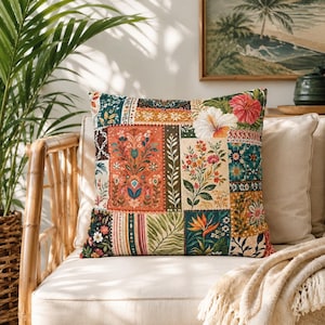 May include: A square throw pillow featuring a patchwork design of various floral and botanical patterns. The fabric displays vibrant colors including orange, teal, green, and cream, with illustrations of hibiscus, bird of paradise, and foliage.