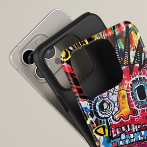 Pu&ograve; includere: Custodia per telefono nera con un design astratto colorato con elementi rossi, gialli, blu e bianchi. La custodia &egrave; sovrapposta a un telefono argentato, mostrando i dettagli vibranti e lo stile artistico.