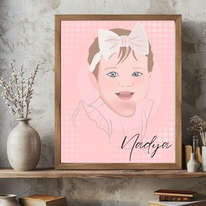 May include: A framed portrait of a baby girl with blue eyes and a white bow. The portrait has a pink background with a dotted pattern and the name "Nadya" in cursive. The frame is made of wood.