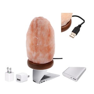 May include: A pink Himalayan salt lamp on a wooden base. The lamp is connected to a USB cable and includes a power adapter and a portable charger. The lamp is shown next to a laptop.