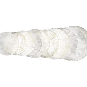 Op de afbeelding: Een verzameling van acht ronde, crèmekleurige onderzetters. De onderzetters hebben een parelmoerachtige, getextureerde afwerking en zijn in een licht gebogen lijn gerangschikt. Eenvoudig en elegant.