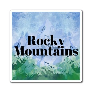 Peut inclure: Une peinture à l'aquarelle des Rocheuses avec un schéma de couleurs bleu et vert. Le texte "Rocky Mountains" est écrit en lettres noires en gras.
