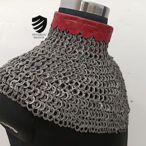 May include: A silver chainmail collar with a red leather trim. The collar is on a black mannequin.
