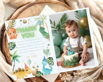 May include: A blue and green dinosaur-themed thank you card with a photo of a baby boy in a white and brown outfit. The card says "Thank You" and "So much for celebrating my 1st birthday with me and for the wonderful present you gave me! I had such a great time playing with all my friends and eating cake. Love, Oliver."