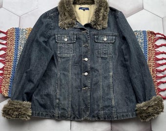 Peut inclure: Une veste en jean bleu foncé avec un col et des poignets en fausse fourrure. La veste a une fermeture à boutons et deux poches sur le devant.