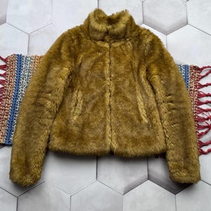 May include: A brown faux fur jacket with a high collar and zipper closure.