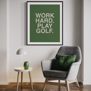 K&ouml;nnte beinhalten: Ein gerahmter Druck mit gr&uuml;nem Hintergrund und wei&szlig;em Text, der "WORK HARD. PLAY GOLF." lautet.