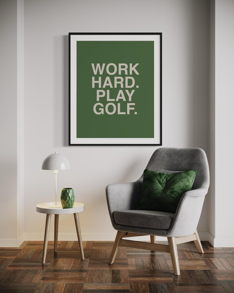 K&ouml;nnte beinhalten: Ein gerahmter Druck mit gr&uuml;nem Hintergrund und wei&szlig;em Text, der "WORK HARD. PLAY GOLF." lautet.