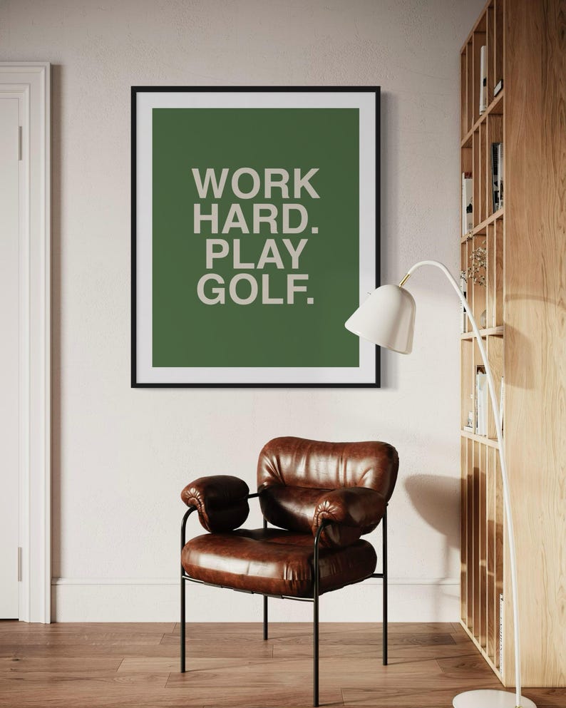 K&ouml;nnte beinhalten: Ein gerahmter Druck mit gr&uuml;nem Hintergrund und wei&szlig;em Text, der "WORK HARD. PLAY GOLF." lautet.