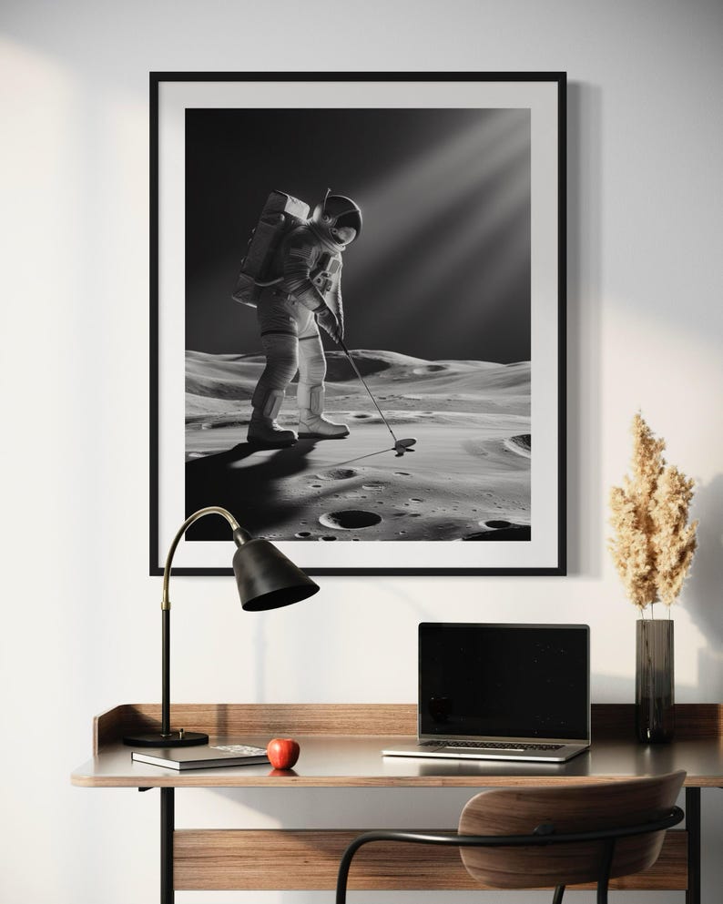 K&ouml;nnte beinhalten: Ein Schwarzwei&szlig;foto eines Astronauten, der auf dem Mond Golf spielt. Der Astronaut tr&auml;gt einen Raumanzug und h&auml;lt einen Golfschl&auml;ger in der Hand. Die Mondoberfl&auml;che ist im Hintergrund zu sehen.