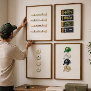 Peut inclure: Quatre impressions encadrées présentant des œuvres d'art sur le thème du golf. L'une affiche des tees de golf avec des noms de tournois, une autre des boîtes d'allumettes, et deux autres des balles et casquettes de golf. Les cadres sont bruns, et le fond est blanc.