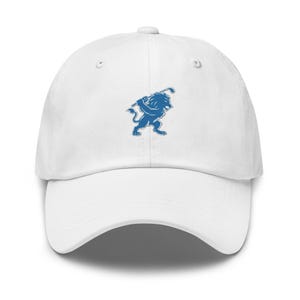 May include: White baseball cap featuring a blue lion graphic holding a golf club. The cap has a curved brim and an adjustable strap. The lion graphic is a stylized design, adding a sporty touch to the hat.