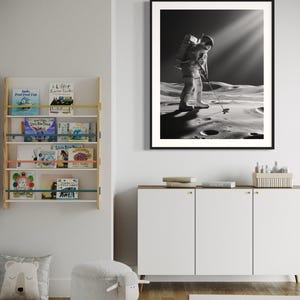 K&ouml;nnte beinhalten: Ein Schwarzwei&szlig;foto eines Astronauten, der auf dem Mond Golf spielt. Der Astronaut tr&auml;gt einen Raumanzug und einen Rucksack. Die Mondoberfl&auml;che ist im Hintergrund zu sehen.
