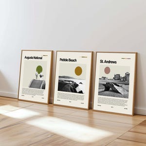 May include: Three framed art prints depicting golf course scenes. The prints are labelled "Augusta National," "Pebble Beach," and "St. Andrews." Each print has a minimalist design with a neutral colour palette, including beige, brown, and muted colours. The prints are leaning against a white wall.