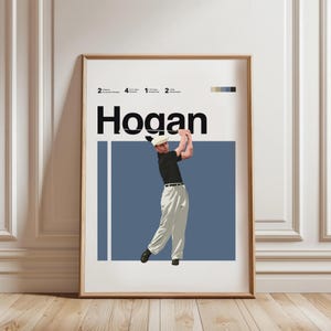 Puede incluir: Un póster enmarcado con una ilustración estilizada de un golfista en acción. El fondo es azul con el nombre "Hogan" en letras negras grandes. El póster también incluye los triunfos del golfista.