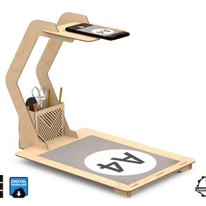 Puede incluir: Un organizador de escritorio de madera con un soporte para teléfono, un porta lápices incorporado y una superficie gris marcada con "A4".