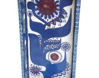 May include: A rectangular ceramic wall-mounted candle holder with a blue and white glazed finish. The interior features a dark blue and maroon floral pattern on a white background. A single cylindrical candle cup is at the base, with a hanging hole.