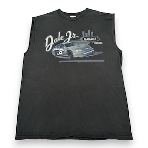 Puede incluir: Camiseta sin mangas negra con un gráfico de un coche de carreras, el número 8 y el texto "Dale Jr." y "Garage Threads". La camiseta está hecha de un material suave y desgastado.