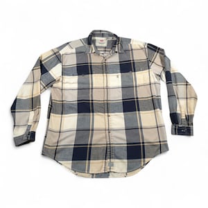 May include: A long-sleeved plaid shirt in cream, navy, and grey. The shirt has a button-down front, two chest pockets, and buttoned cuffs. The Levi's brand label is visible on the collar. A classic casual garment.