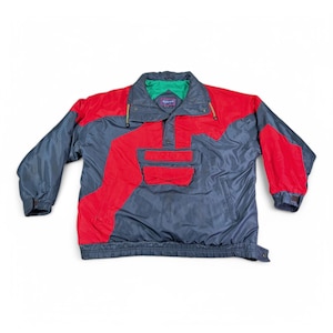 May include: A vintage anorak-style jacket in a color block design. The jacket features a red and navy blue color scheme with a green collar lining. It has a front pocket and a drawstring at the waist. The jacket has a zipper closure.