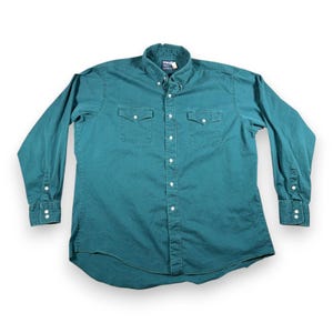 May include: A set of three ceramic mugs with a speckled, matte finish. The mugs are in shades of cream, light brown, and dark brown. Each mug has a rounded handle and a simple, minimalist design.