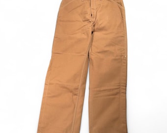 Calça Carhartt vintage masculina, tamanho 38x33, em lona marrom, fabricada nos EUA, com 100 anos de história (anos 80).