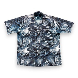 Op de afbeelding: Een shirt met korte mouwen met een blauw en wit patroon van gitaren en het Hard Rock Cafe-logo. Het shirt heeft een kraag en de tekst "Newport Beach" is zichtbaar.