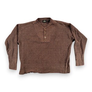 May include: A brown knitted sweater with a button-up placket and long sleeves. The sweater has a ribbed texture and a crew neck. The buttons are a darker shade of brown. The sweater is a medium weight.
