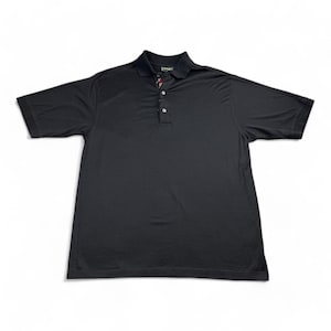May include: A black polo shirt with short sleeves and a collared neckline. The shirt has a three-button placket and a small logo detail near the collar. The fabric appears to be a lightweight, breathable material.
