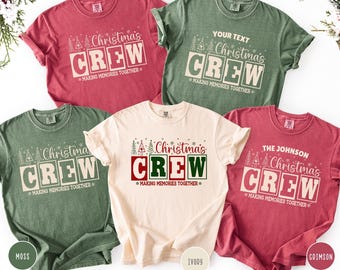 Puede incluir: Cinco camisetas en varios colores, cada una con el texto "Christmas CREW" en un diseño festivo. Las camisetas son en tonos de rojo, verde e marfil, con la frase "MAKING MEMORIES TOGETHER" debajo del texto principal. Algunas camisetas tienen texto personalizable.