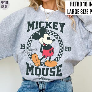 Może przedstawiać: Szara bluza z nadrukiem w stylu retro z Myszki Miki. Projekt przedstawia Myszkę Miki, napisy "Mickey Mouse" i rok "1928". Widoczny jest r&oacute;wnież tekst "Retro 16 inch Large Size Print".