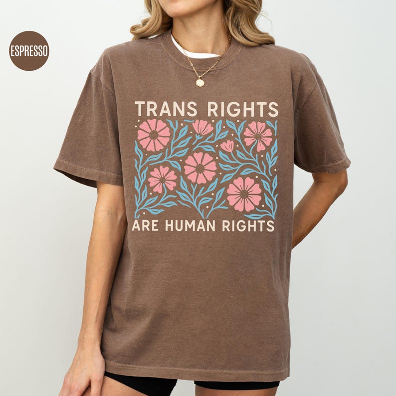 May include: A brown t-shirt with a floral design and the text "Trans Rights Are Human Rights".