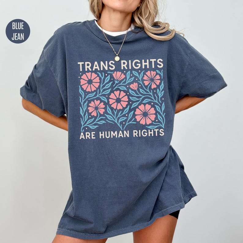 May include: A dark blue oversized t-shirt with a floral design and the text "Trans Rights Are Human Rights".