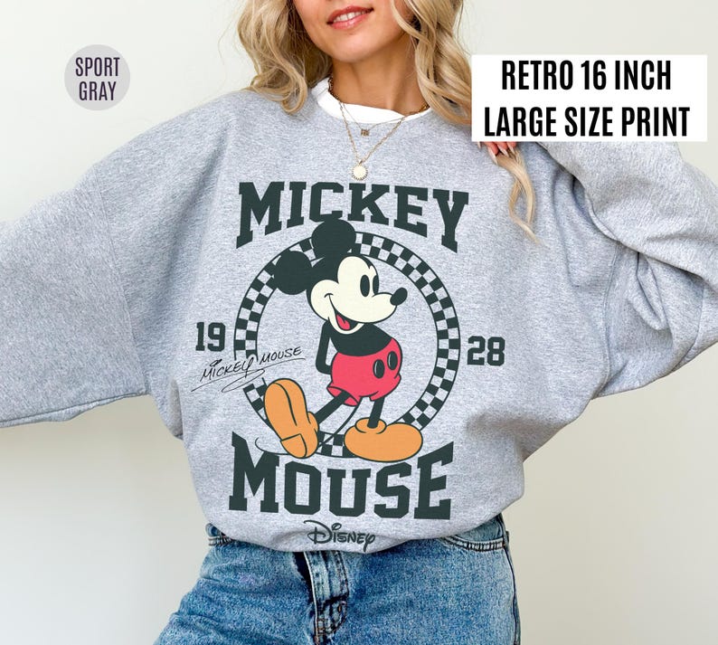 Może przedstawiać: Szara bluza z nadrukiem w stylu retro z Myszki Miki. Projekt przedstawia Myszkę Miki, napisy "Mickey Mouse" i rok "1928". Widoczny jest r&oacute;wnież tekst "Retro 16 inch Large Size Print".