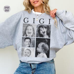 May include: Sport grey sweatshirt with the word "GIGI" printed in black. The sweatshirt features a collage of four black and white photos of children. The sweatshirt is made of a soft material.