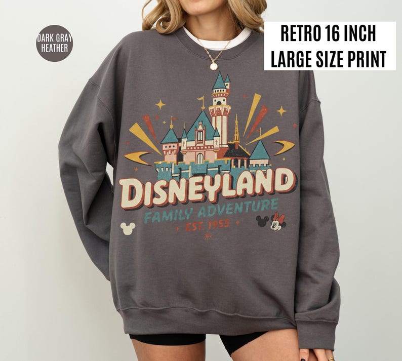 May include: Dark gray heather sweatshirt with a retro Disneyland graphic. The design features a castle, stars, and the text "Disneyland Family Adventure Est. 1955". The print is 16 inches in size.