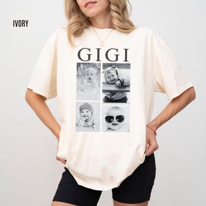May include: Ivory t-shirt with the word "GIGI" printed in black on the front. The shirt features four black and white photos of babies in a grid pattern.
