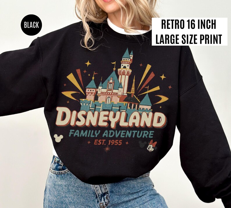 May include: Black sweatshirt with a retro Disneyland graphic. The design features a castle, the word "Disneyland", and the text "Family Adventure + EST. 1955 +." The sweatshirt has the text "RETRO 16 INCH LARGE SIZE PRINT" and the word "BLACK" on it.