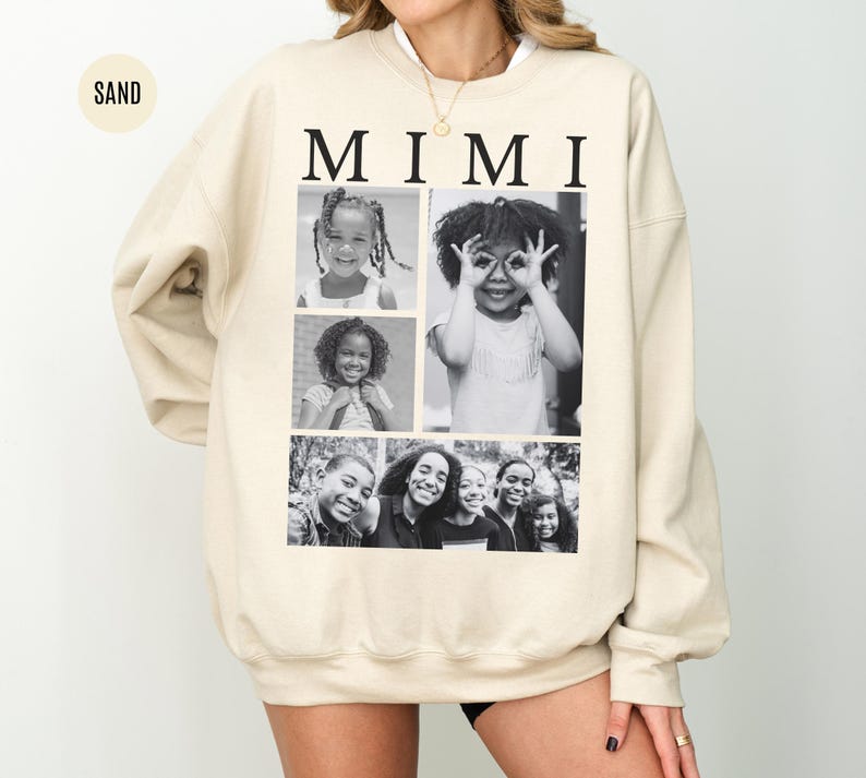 May include: A sand-coloured sweatshirt with the word "MIMI" in black capital letters. The sweatshirt displays a collage of black and white photographs of children. The style of the sweatshirt is casual and comfortable.