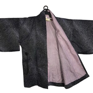 May include: A black and white patterned kimono with a pink lining. The kimono has a traditional Japanese style.