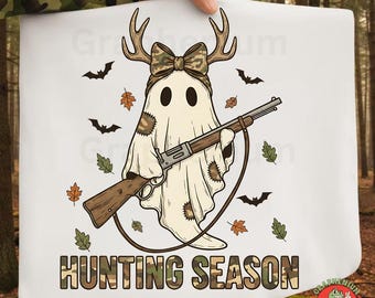 May include: White graphic featuring a ghost with deer antlers and a camouflage bow, holding a rifle. The ghost has patches and is surrounded by bats and leaves. The text "HUNTING SEASON" is in camouflage.