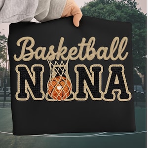 May include: Black pillow with the words "Basketball NANA" in a beige, embroidered font. The word "Basketball" is arched above the word "NANA". A basketball is inside a net, with a heart on the ball.