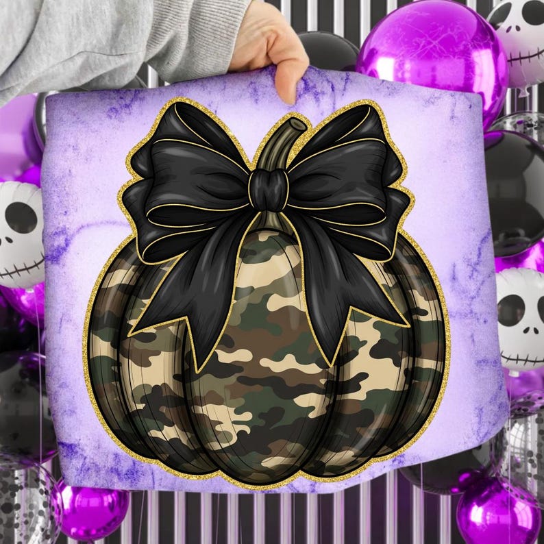 May include: A decorative square pillow featuring a camouflage pumpkin design with a large black bow and gold trim. The pumpkin is set against a purple background with a marble effect, perfect for Halloween or fall decor.