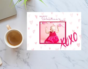 May include: A pink Valentine's Day card with a pink heart pattern and a photo of a baby girl in a pink dress. The card says "Happy Valentine's Day!" and "XOXO" in pink.